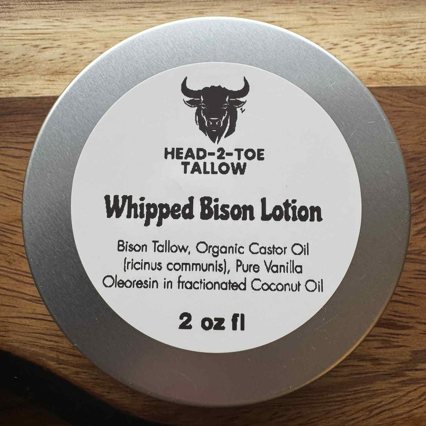 Whipped bison lotion container with label on a wooden surface